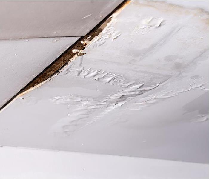 "a white ceiling showing signs of water damage from a leak " 